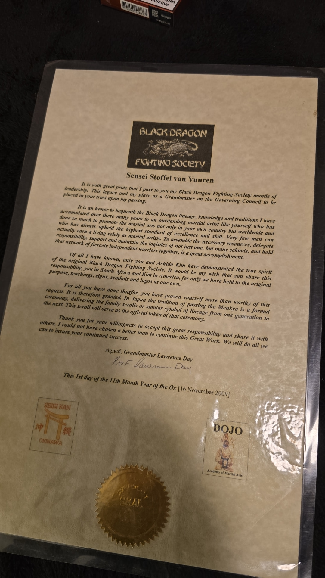 The 2009 Menkyo scroll signed by Grandmaster Lawrence Day passing the Black Dragon Fighting Society mantle of leadership to Sensei Stoffel van Vuuren